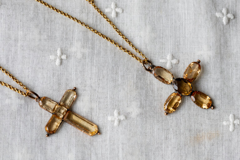 Two topaz crosses on a gold chain