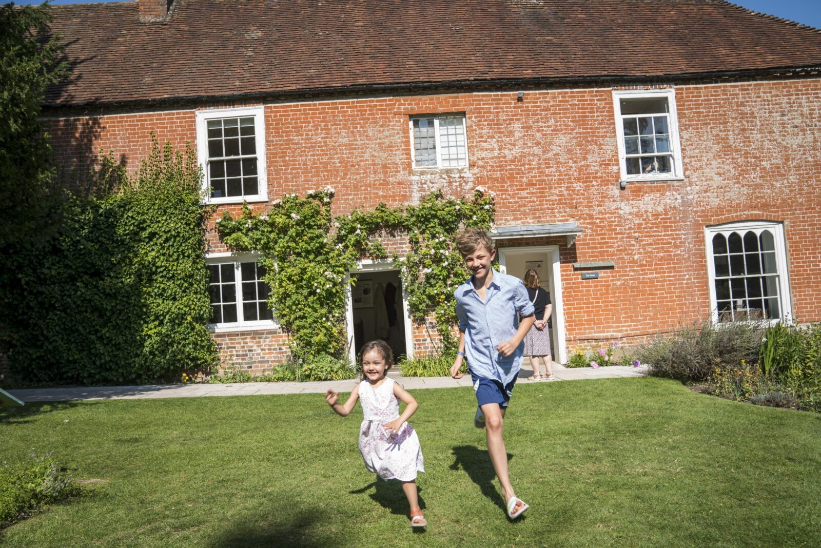Children running across the lawn at Jane Austen's House