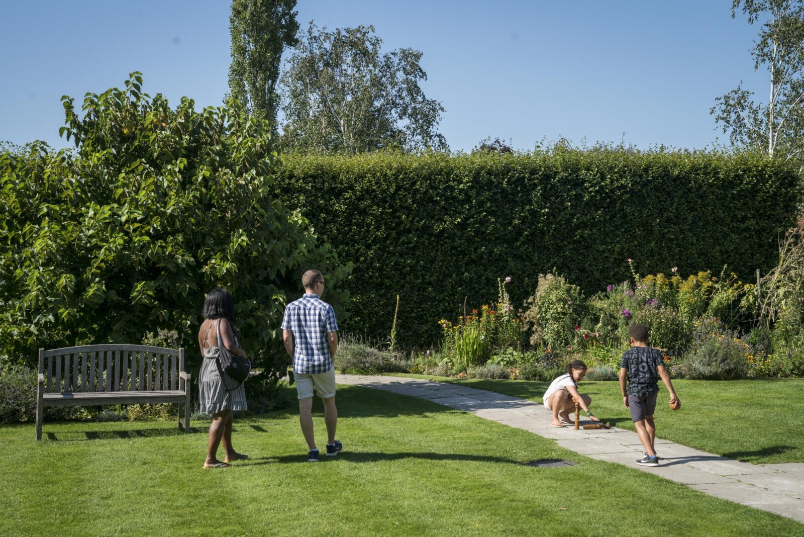 People walking and playing in the garden at Jane Austen's House. Photo by Rob Stothard