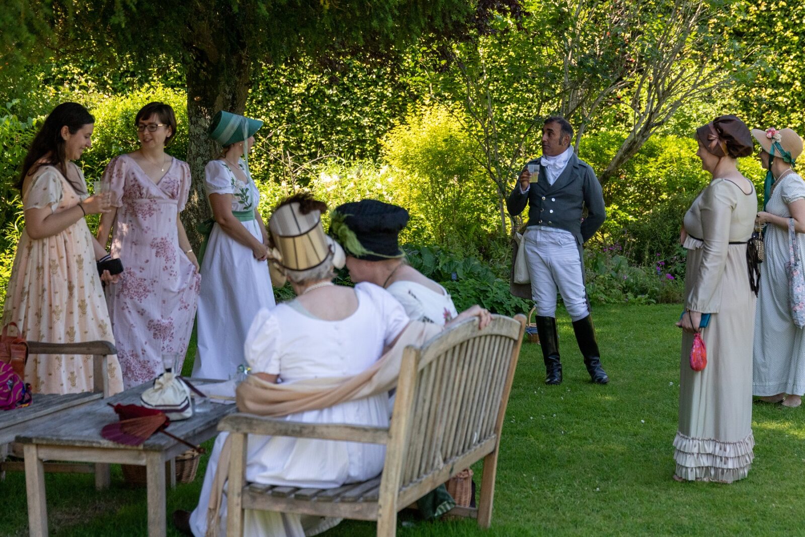 A group of people in Regency dress in the garden at Jane Austen's House