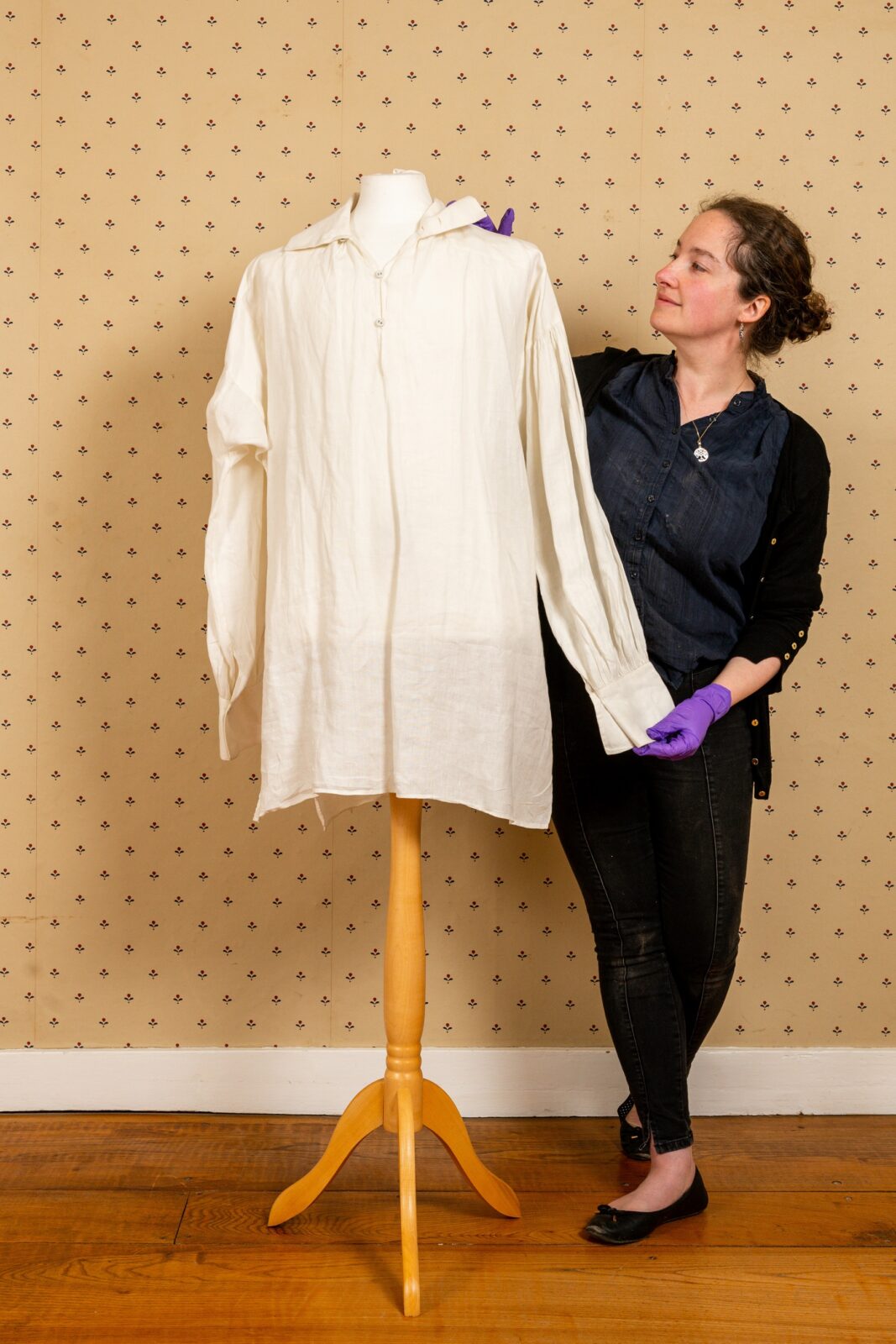 Director Lizzie Dunford tweaks the Mr Darcy shirt, on display at Jane Austen's House in 2022 as part of our Jane Austen Undressed exhibition