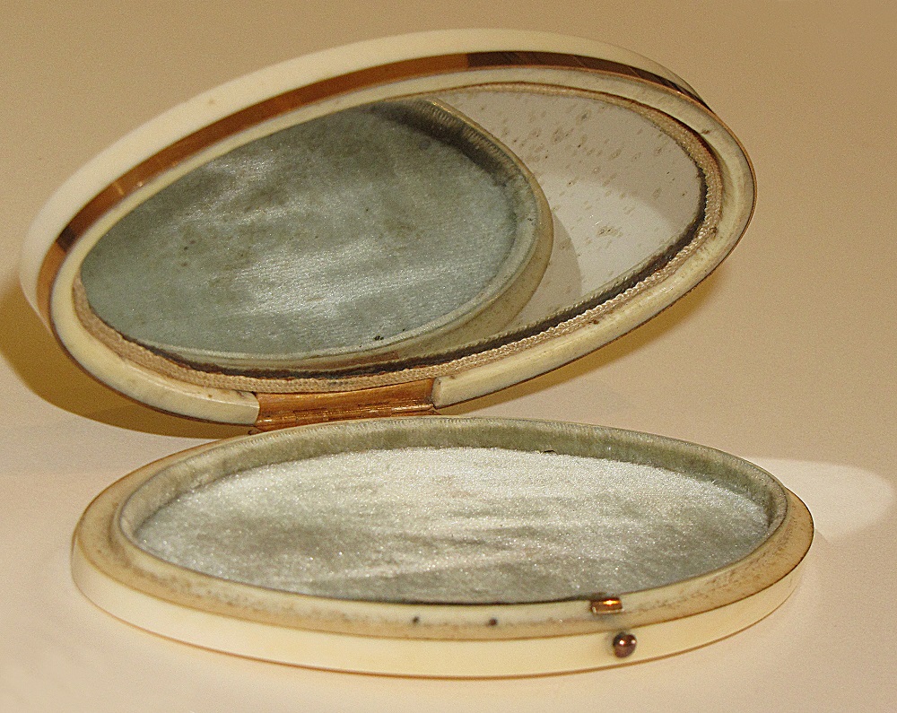 Ivory and gold mounted oval patchbox. The interior contains a velvet pad; the inside of the lid is inset with a mirror.